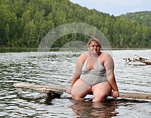 Overweight woman sitting on stage