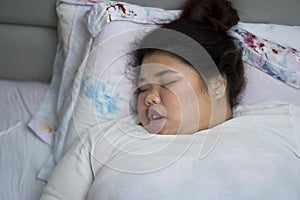 Overweight woman sleeping with open mouth, snoring