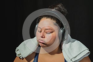 Overweight woman in sportswear on black background