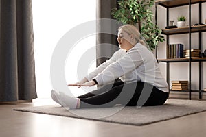 Overweight woman stretching at home