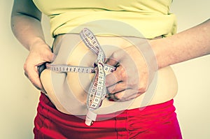 Overweight woman with tape measure - obesity concept