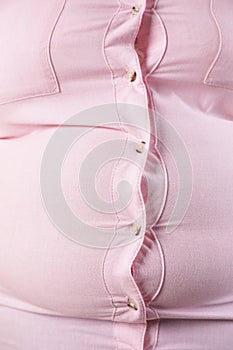 Overweight woman in tight shirt. Obesity and weight loss