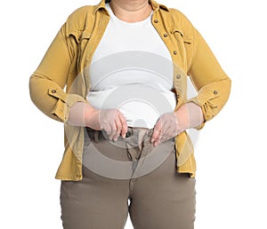 Overweight woman trying to button up tight trousers on white background, closeup