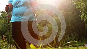 Overweight woman walking on forest trail.