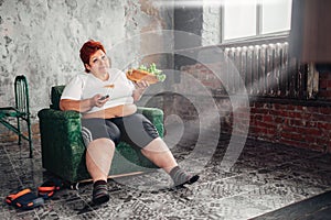 Overweight woman watches TV, bulimic, fatty