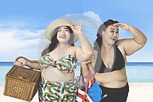 Overweight women looking something on beach