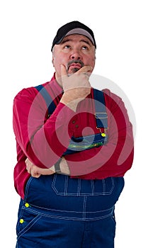 Overweight worker in overalls standing thinking
