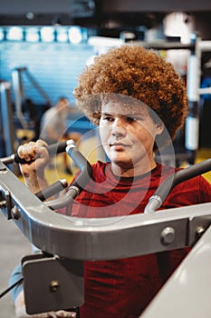 Overweight young man exercising in gym to achieve goals