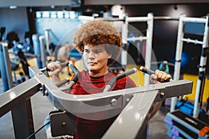 Overweight young man exercising in gym to achieve goals