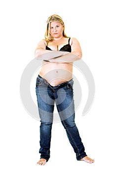 Overweight young woman in bra and jeans on white