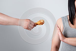 Overweight young women reject fried food. She is losing weight on a white background