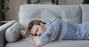 Overwhelmed 30s businessman flopping down on sofa, needs rest.