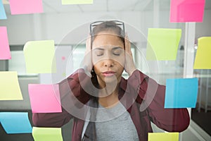 overwhelmed businesswoman surrounded by post-it notes