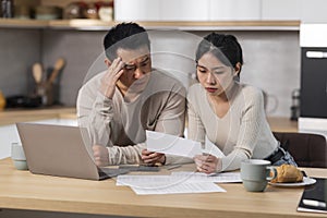 Overwhelmed chinese spouses reading correspondence at home