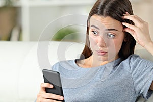 Overwhelmed girl discovering mistake on smart phone photo