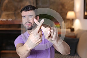 Overwhelmed man rejecting with cross gesture