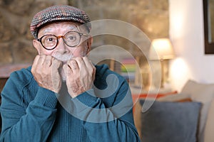 Overwhelmed senior man biting nails with anxiety