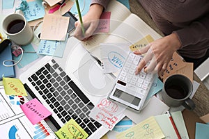 Overwhelmed woman working at messy office desk  top view