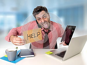 Overworked businessman busy at office desk working on computer and tablet