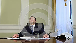 Overworked businessman falling asleep in office