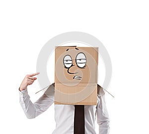 overworked businessman pointing on cardboard box on his head