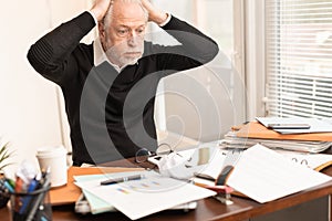 Overworked businessman sitting at a messy desk