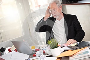 Overworked businessman sitting at a messy desk