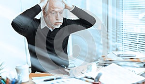 Overworked businessman sitting at a messy desk  light effect