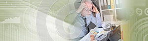 Overworked businessman sitting at a messy desk, light effect. panoramic banner