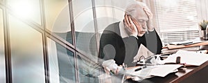 Overworked businessman sitting at a messy desk; multiple exposure