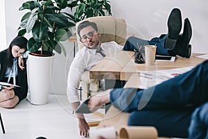 overworked businessman sleeping at office with feet