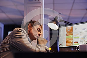 Overworked corporate manager falling asleep on desk table