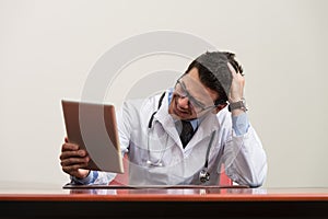 Overworked Doctor Sitting By His Desk