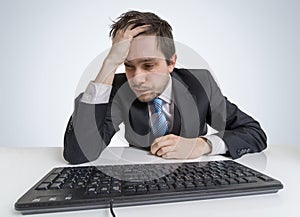 Overworked and exhausted businessman is working with computer
