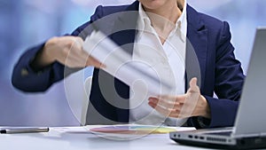 Overworked female employee checking piles of documents and graphs, deadline