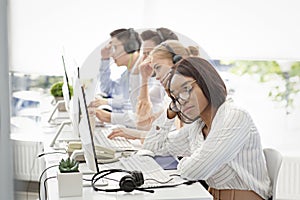 Overworked female helpline consultant procrastinating near computer monitor at call centre, blank space