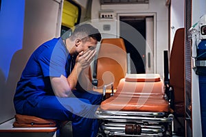 Overworked paramedic falling asleep in an ambulance car