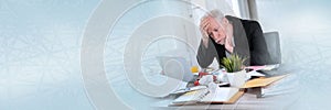 Overworked businessman sitting at a messy desk; panoramic banner