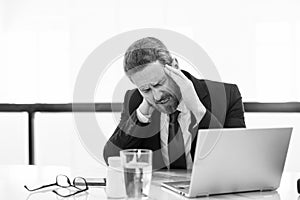overworked stressed business man has headache pain. photo of stressed business man has headache