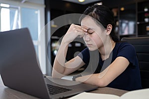 Overworked tired schoolgirl rubbing her nose bridge,closing eyes to rest her eyes,stressed asian girl having headache,blurry