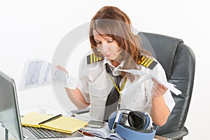 Overworked woman airline pilot in the office