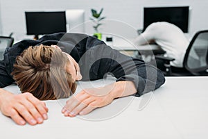 overworked young manager sleeping on work