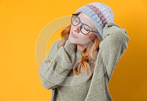 Overworked young woman have a pain in neck, isolated on yellow background. Tired female with closed eyes