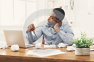 Overworking african-american employee at workplace