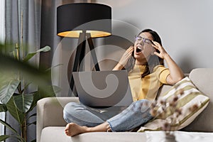 Overworking multi-ethnic attractive woman yawning tired student working on laptop in the evening at home