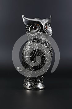 Owl a decorative figure, from different materials, against a dark background.