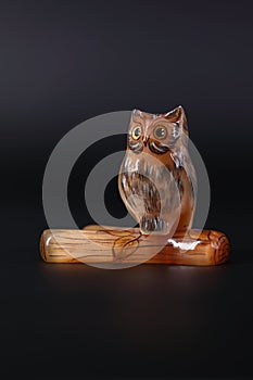 Owl a decorative figure, from different materials, against a dark background.