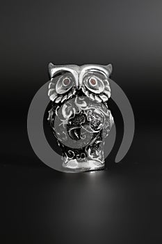 Owl a decorative figure, from different materials, against a dark background.