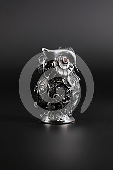 Owl a decorative figure, from different materials, against a dark background.