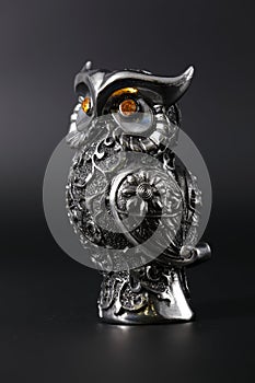 Owl a decorative figure, from different materials, against a dark background.